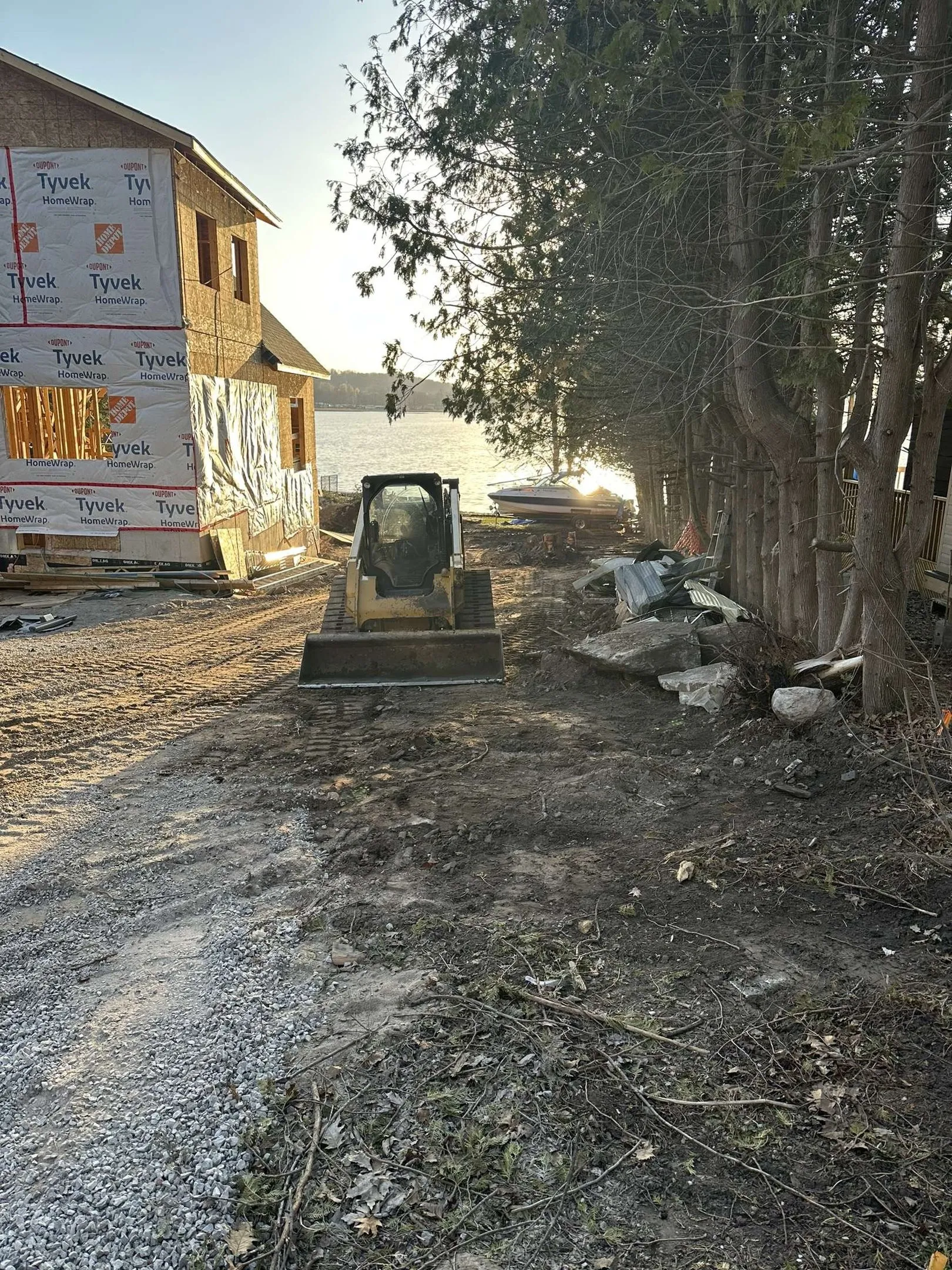 Tracked skid steer working beside a building